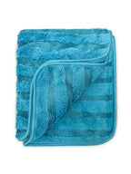 A folded blue terry cloth towel with a plush, textured surface and a slightly lighter blue piping border, shown on a plain white background.